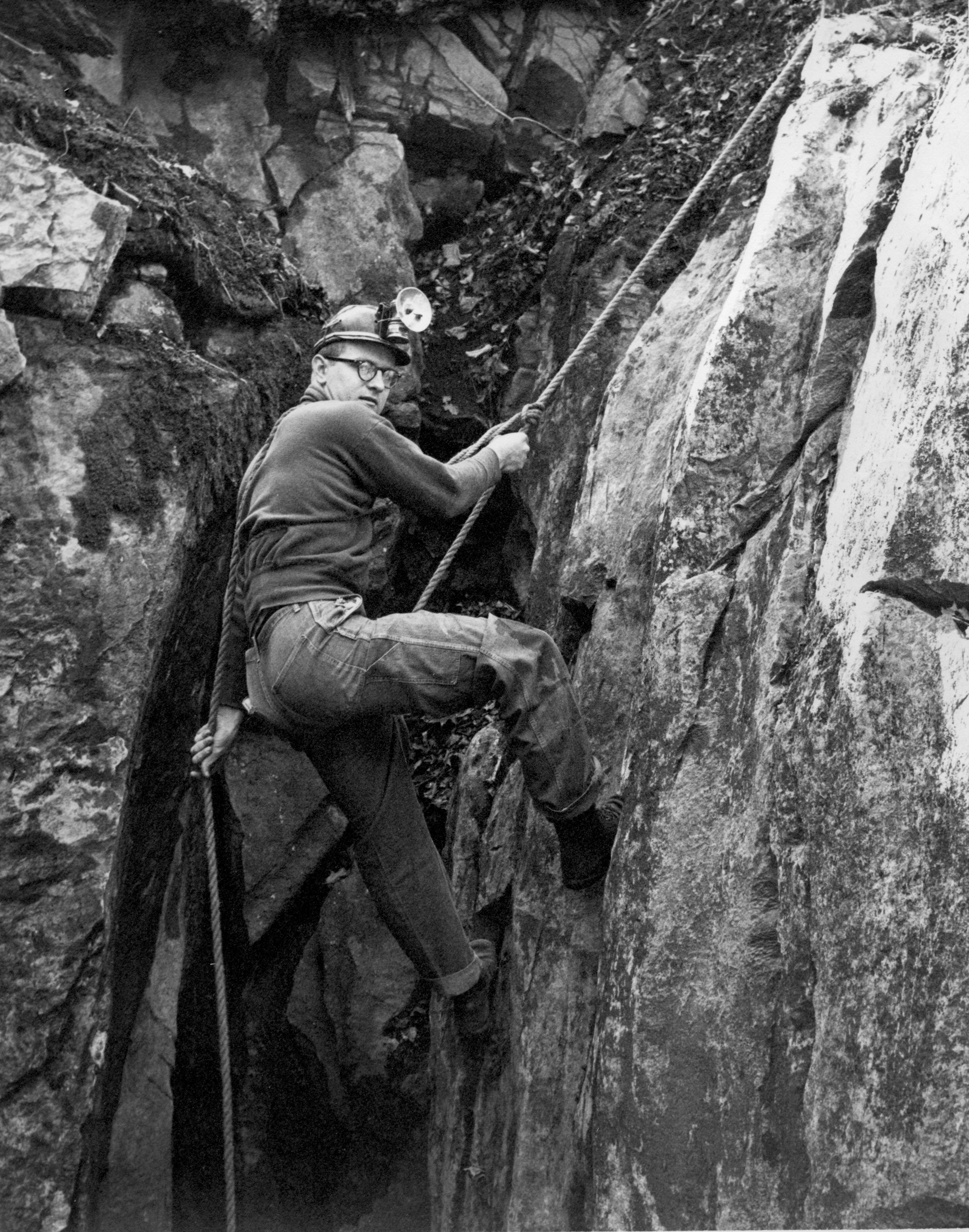 Caver rappels down a cave wall